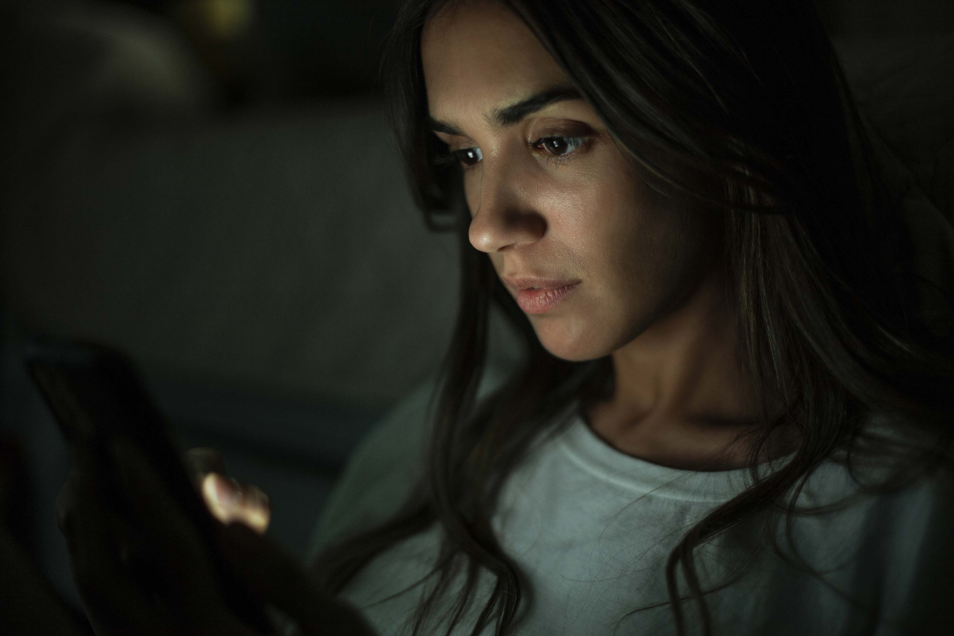 Young woman using digital at home device during night time